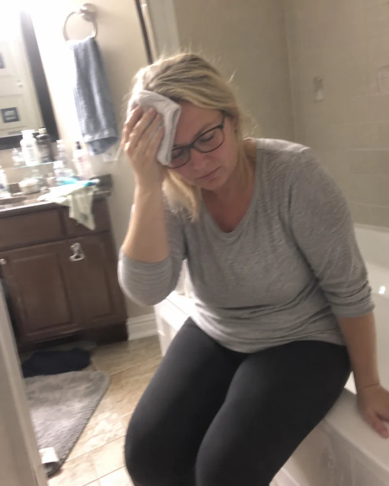 Mujer descansando en el baño con un paño húmedo